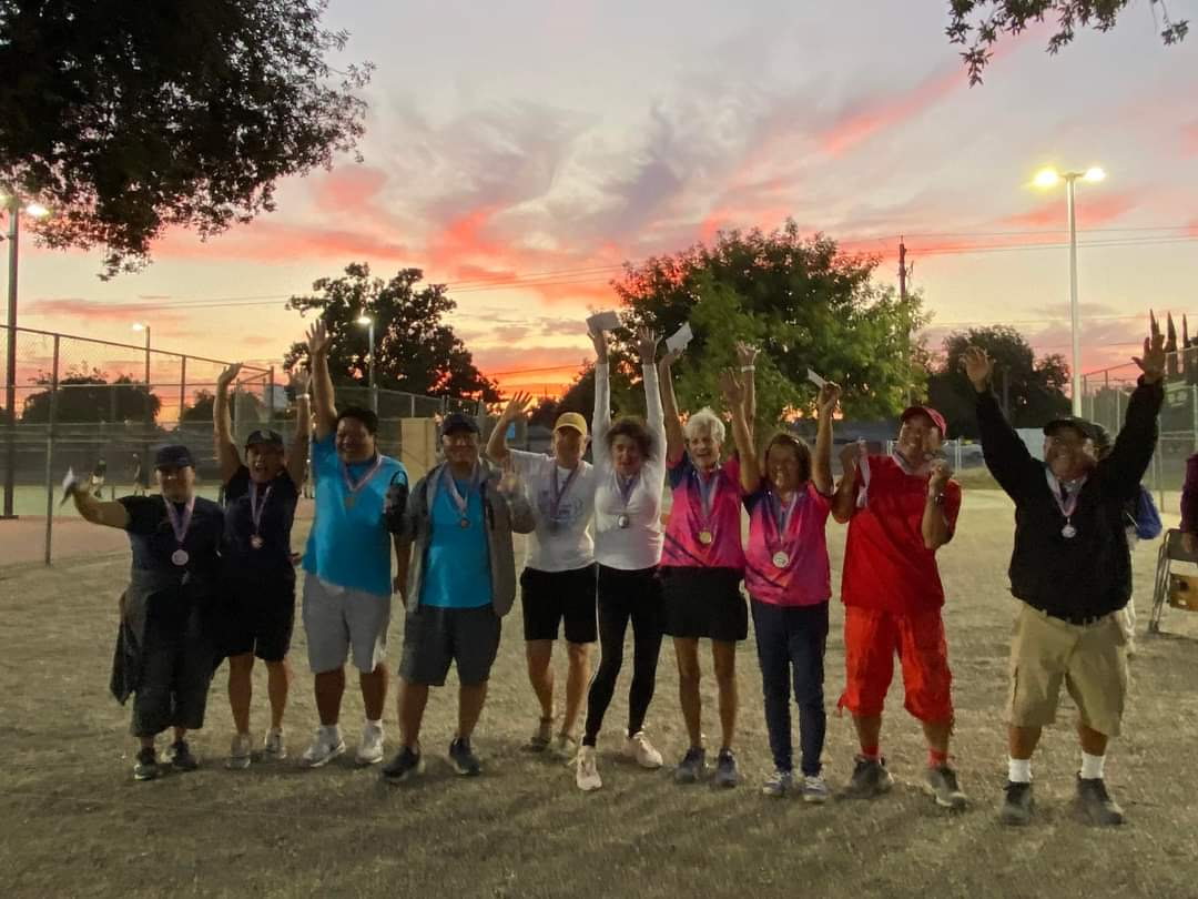 Fresno Pétanque Club players celebrating together at sunset
